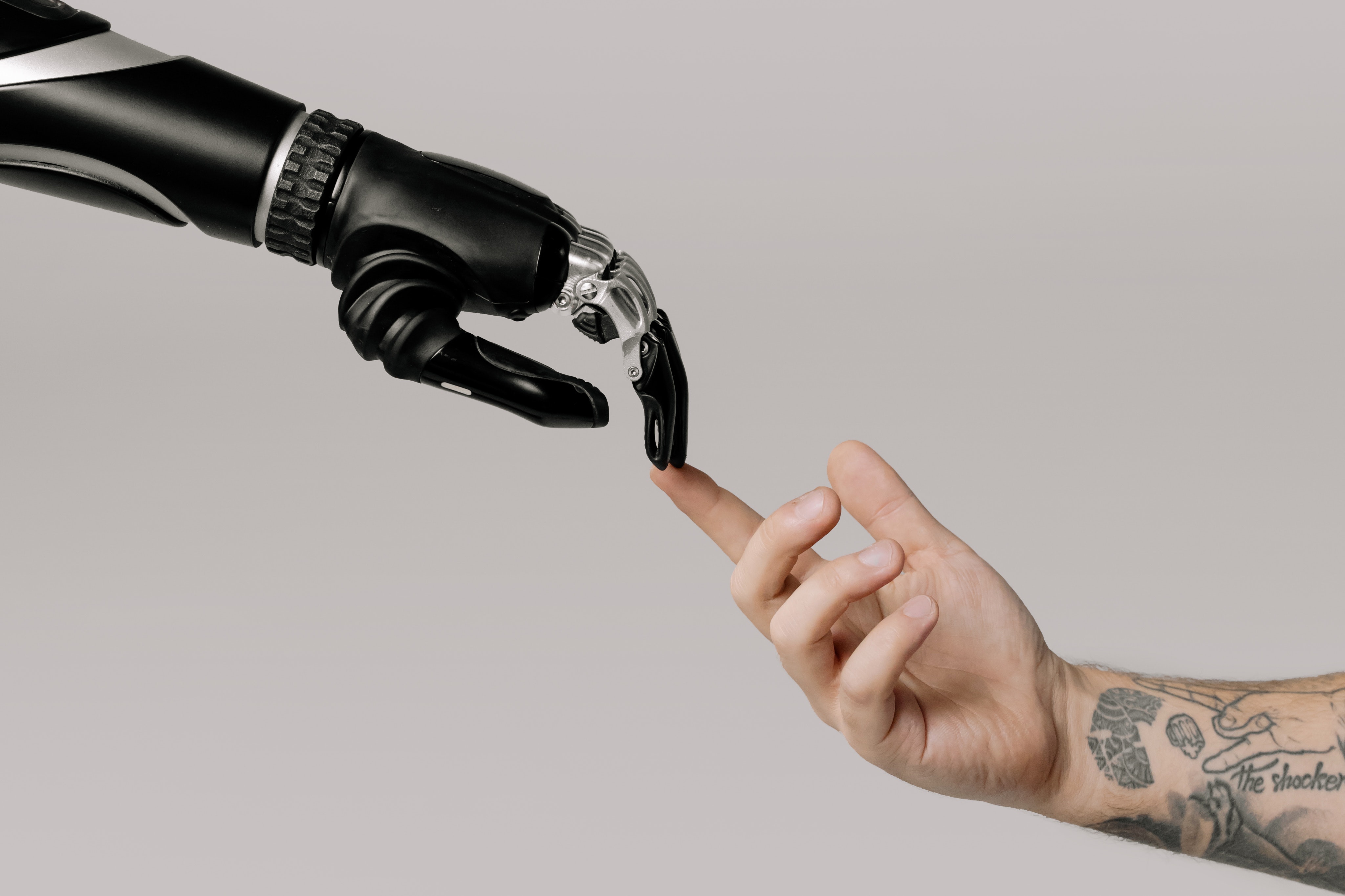 imagem de braço robótico interagindo com humano para ilustrar interação humano e inteligência artificial