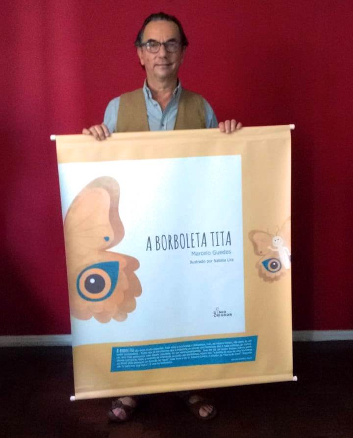 Marcelo com banner do livro